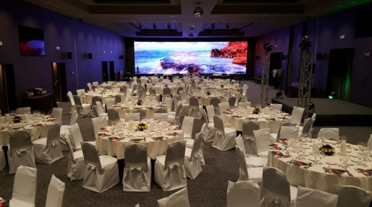 a hall with dining tables and a big screen