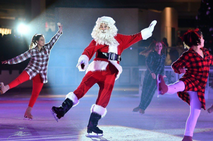 A person wearing Santa attire and skating